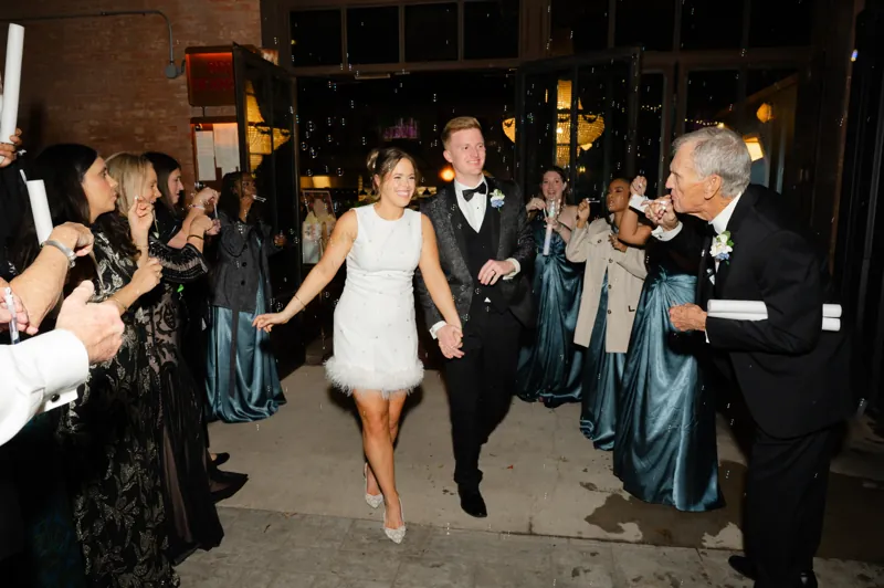 Pearson and Emma walking out through a bubble send-off at their wedding